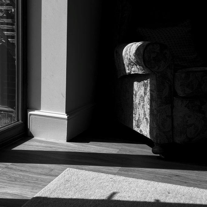 The armchair Black and white photograph of armchair in shadows.