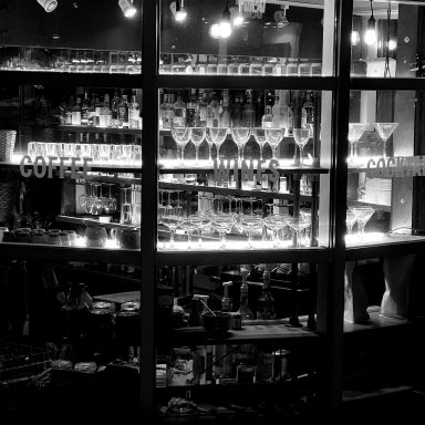 Find a black and white photograph of the window of a coffee shop and bar.