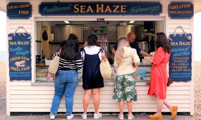 Find photograph of people buying fish at Brighton seaside