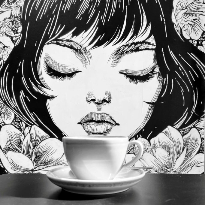 That first coffee Black and white photograph mural and cup of coffee.
