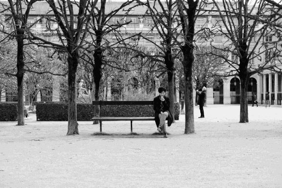 Find a photograph of a man sitting on a bench.