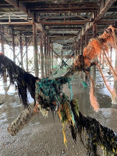 Find photograph of discarded fishing gear wrapped under pier.