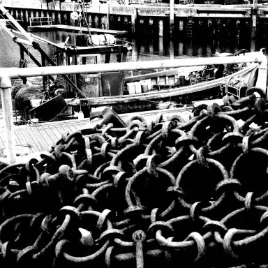 Find a photograph of a fishing boat and trawling chains for sale.