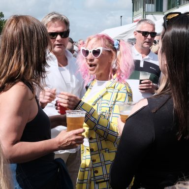 Checks & sunglasses Find a photograph of a colourfully dressed lady at the IOW scooter rally.